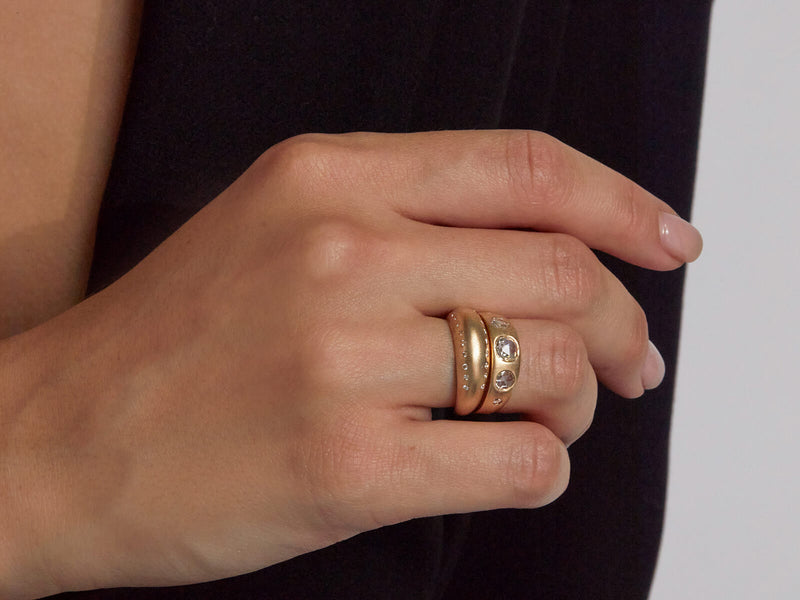 close up of model's hand wearing diamond dome ring stacked with the iris band