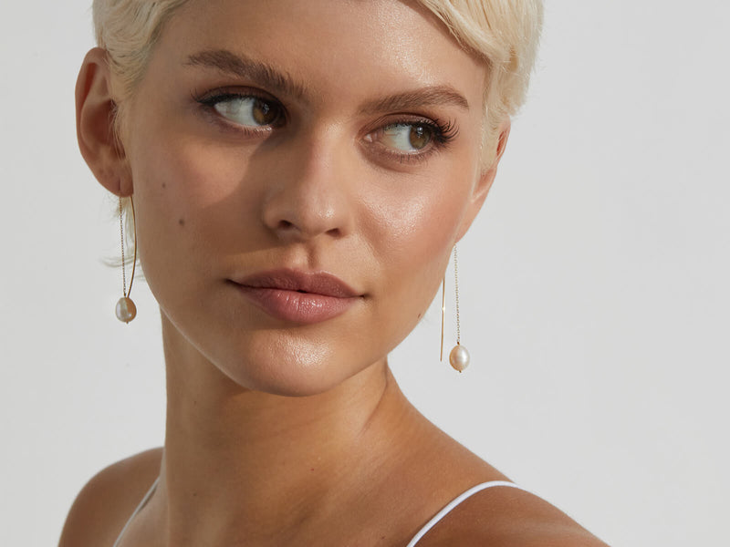 model wearing pearl thread thru earrings