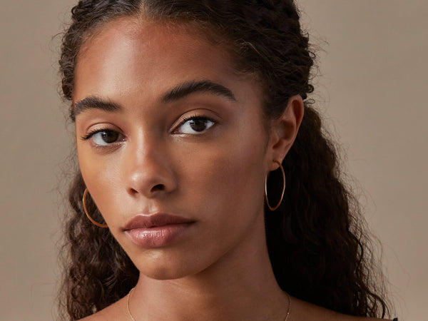 Model wears hoops. They secure behind the ear for seamless wear