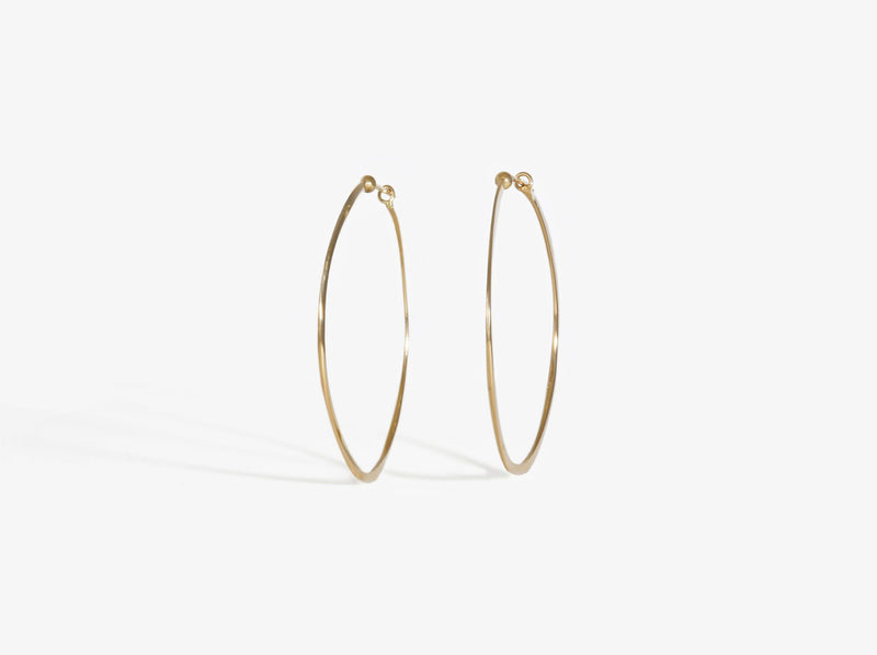 Straight on view to show that earrings do not lie flat, and are a slightly mirrored concave shape that gives them a wave-like shape.