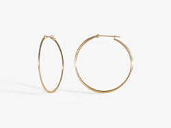 A combined profile and three-quarters view. Earrings close with simple latch and are forged to create an organic wave-like shape.
