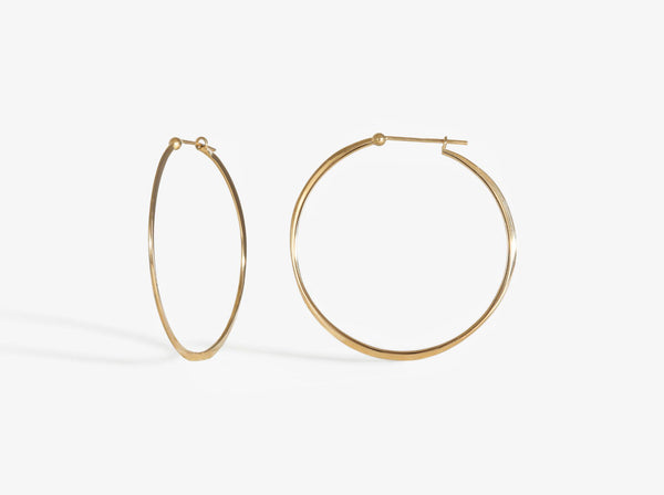 A combined profile and three-quarters view. Earrings close with simple latch and are forged to create an organic wave-like shape.