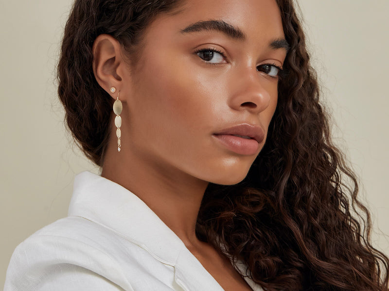 model wears cypress oval earrings with the diamond urchin stud