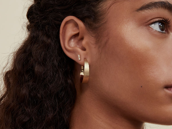 Model wearing Wink Stud in second piercing with the Small Open Forged Hoop in first piercing