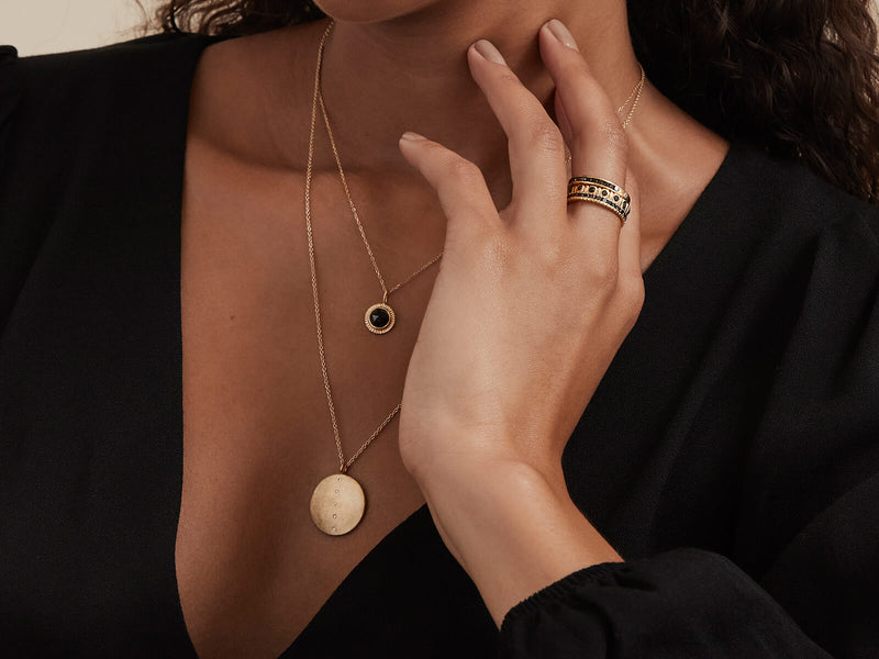 Model wearing necklace layered with Black Diamond Burst Pendant