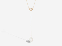Front hanging view. A diamond slice centers a necklace and chain drop with pearl