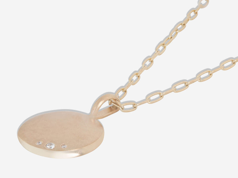 Necklace lying flat to show high polished beveled edge on lower right hand side of oval pendant