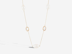 Front hanging view of necklace. Three pearls are equidistant from two diamond slices along the necklace. The chain is centered by a pearl