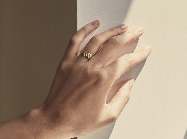 Model wearing the band in gold with a high polish finish
