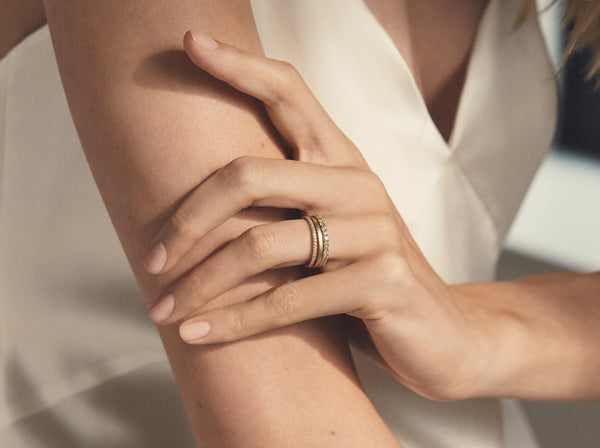 model wears the pipe cut band stacked between a 1 and 2 millimeter eternity band