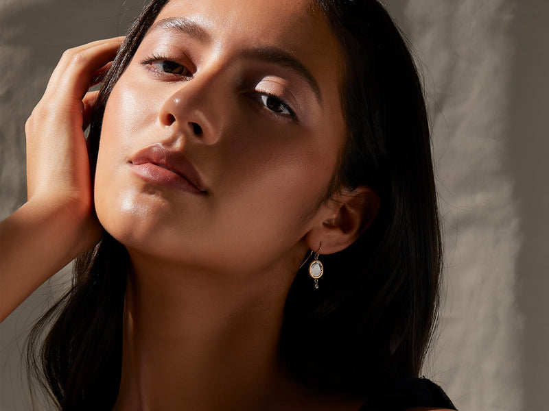 Model wearing diamond slice drop earrings with accent
