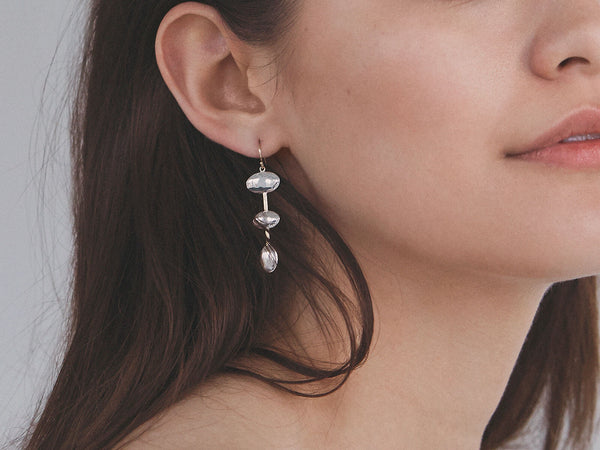 model wearing tri-form earrings with a high polish finish